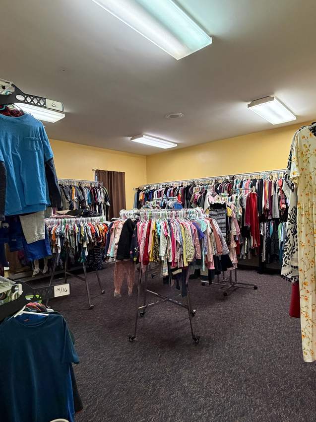 Wide view of organized clothing racks inside Kenny’s Kloset